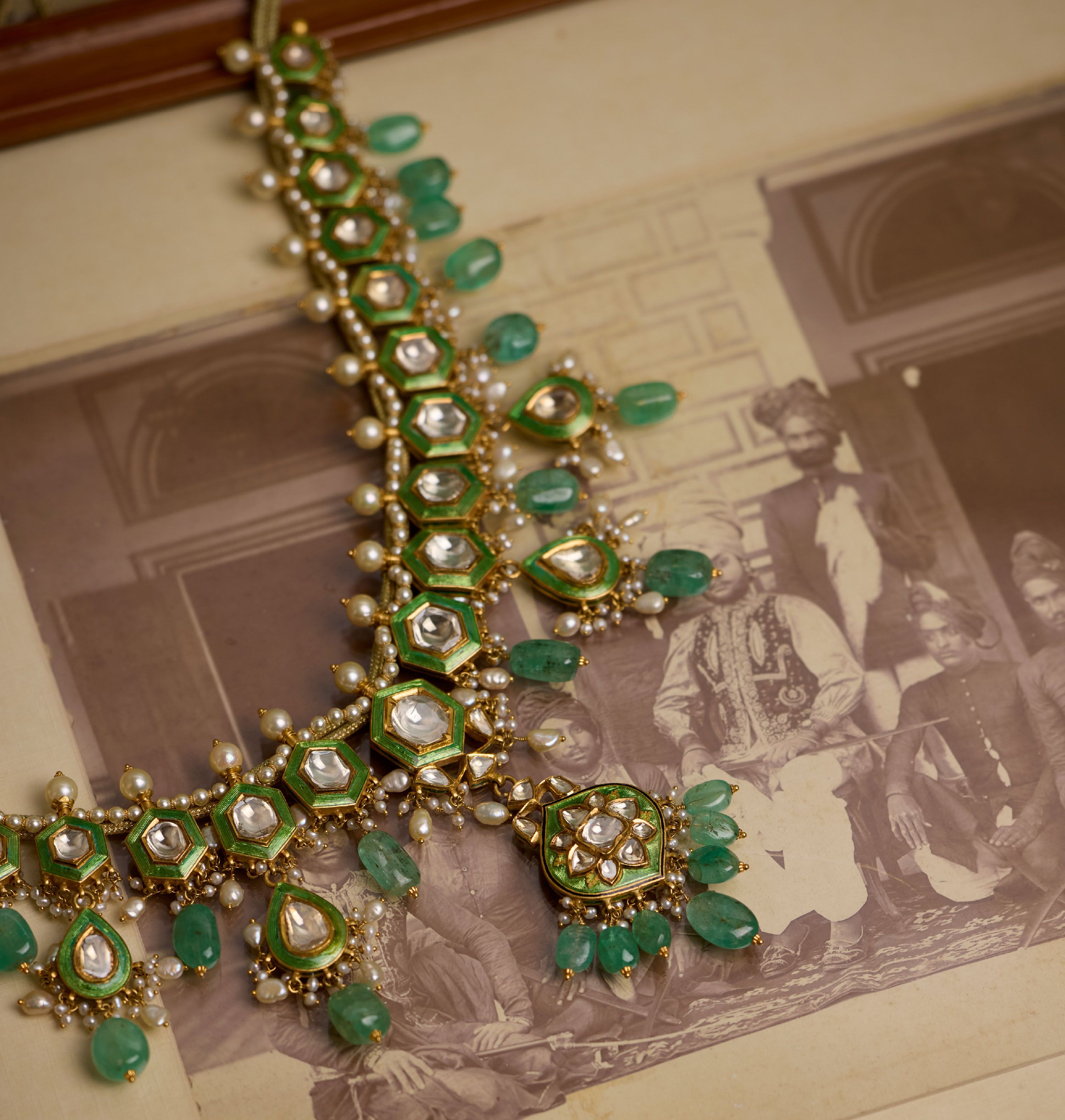 Emerald, pearl and polki haar laid over old photographs