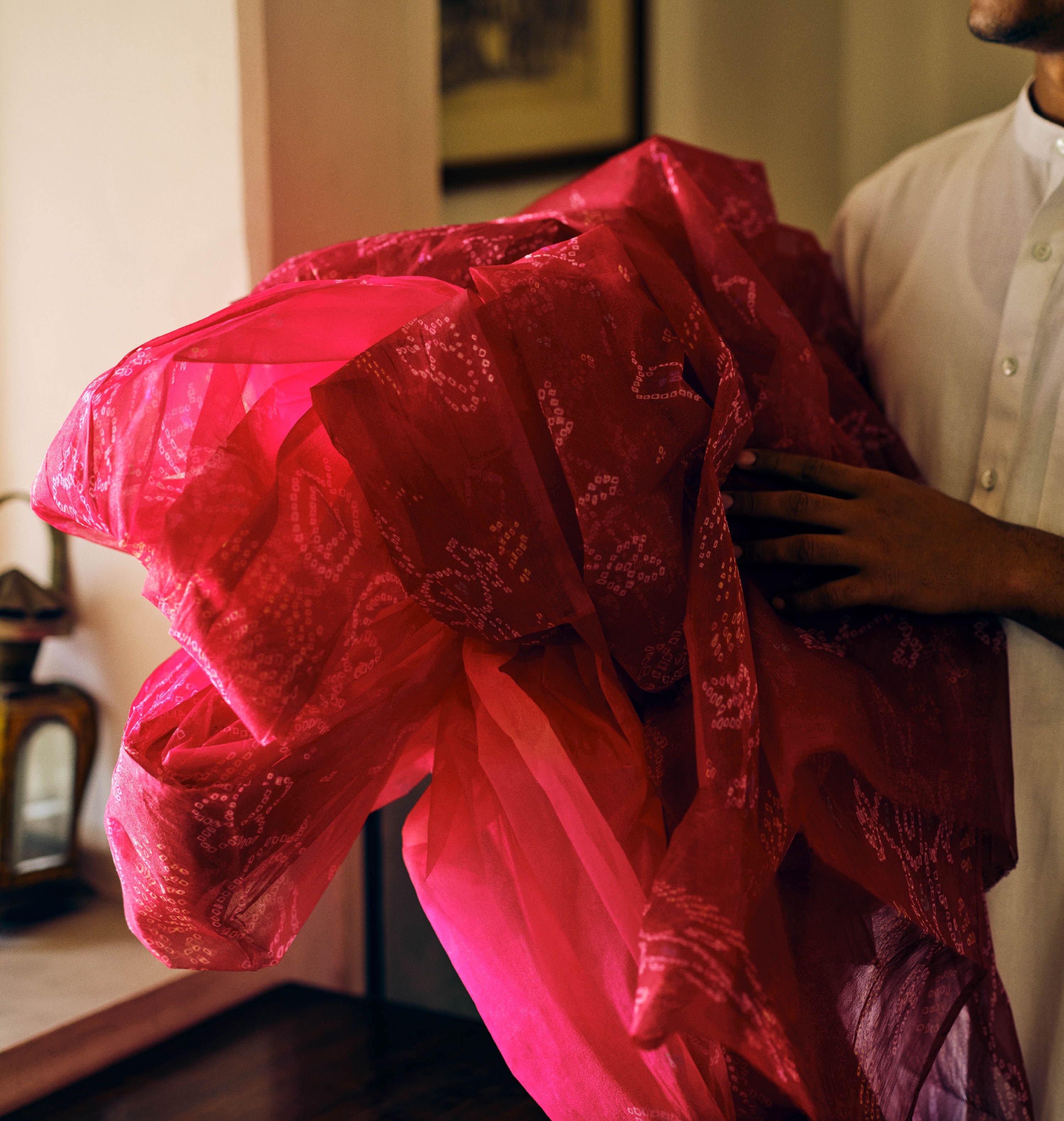 Groom holding a crimson bandhani safa before it is tied